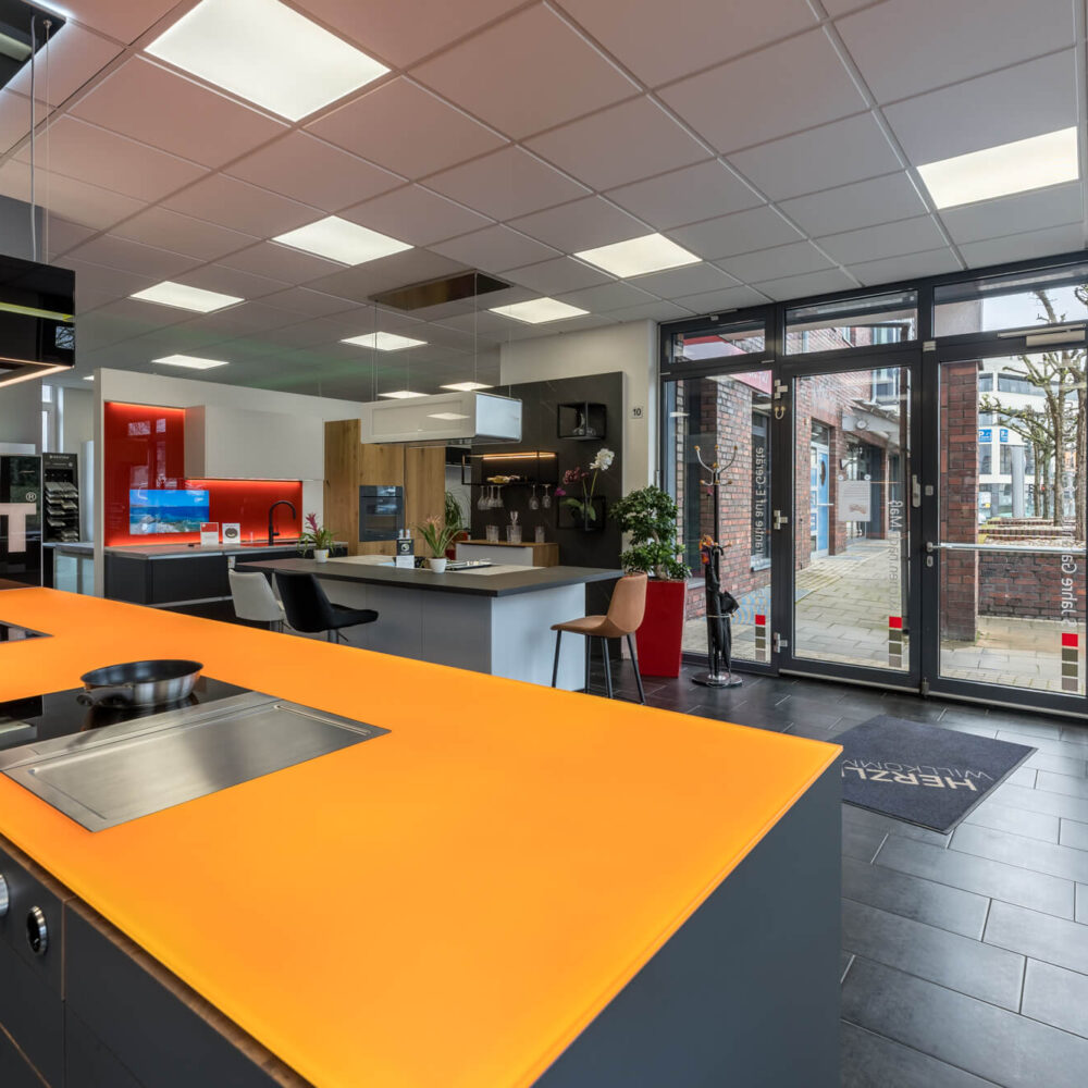 Leicht Inselküche Designküche mit orangener Glas Arbeitsplatte