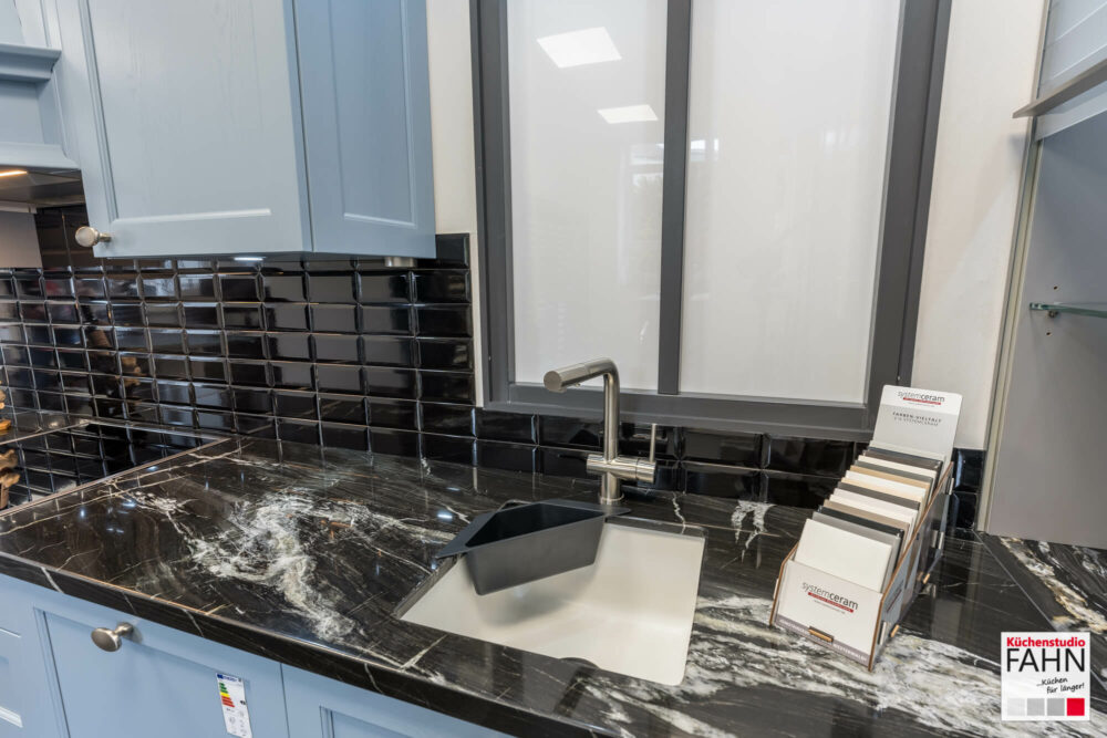 Häcker Landhausküche mit Naturstein Arbeitsplatte schwarz