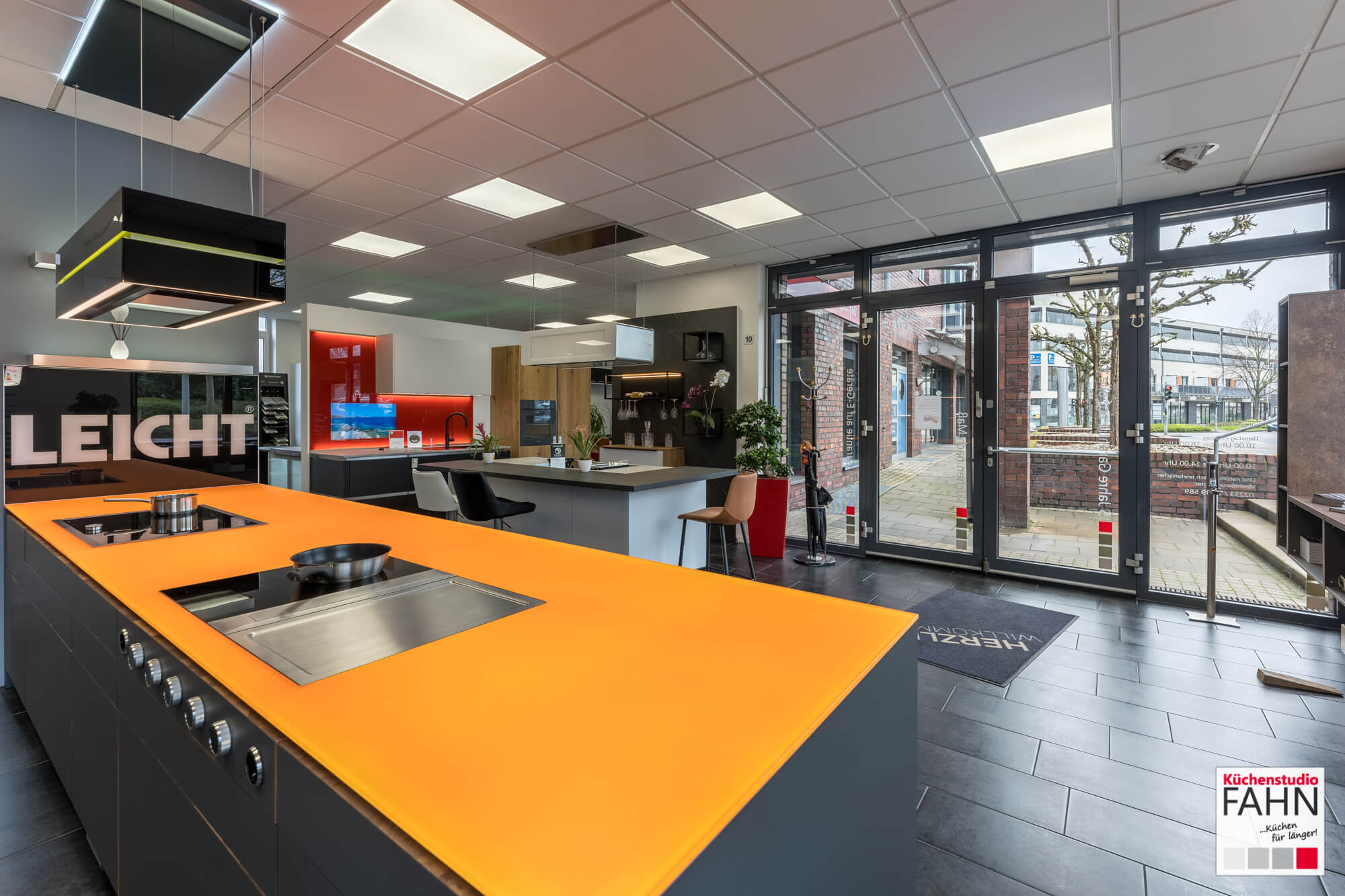 Leicht Inselküche Designküche mit orangener Glas Arbeitsplatte